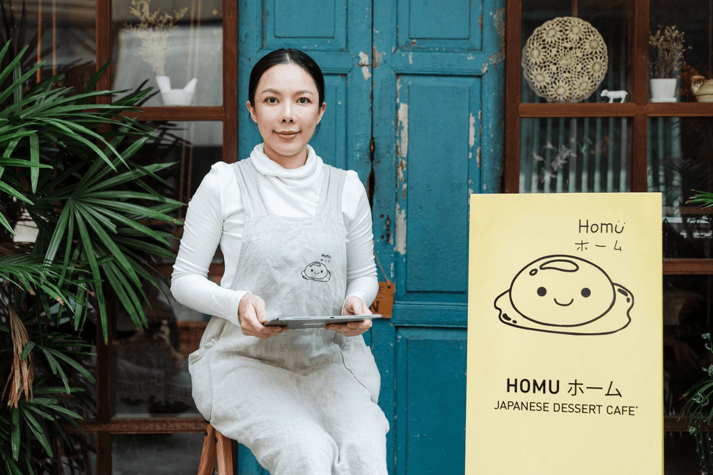 Café owner standing outside her storefront with a tablet, managing her Google Business Profile