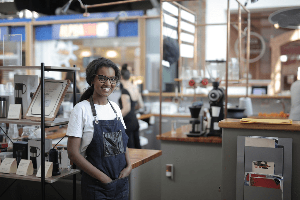 Café owner behind her counter, the kind of regular customer relationship email marketing builds on